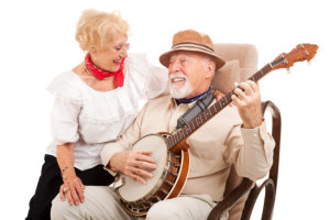 elderly man playing string instrument with his wife