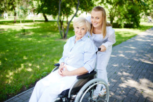 caregiver and elderly woman outside the house