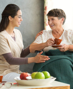 caregiver served tea for elderly woman